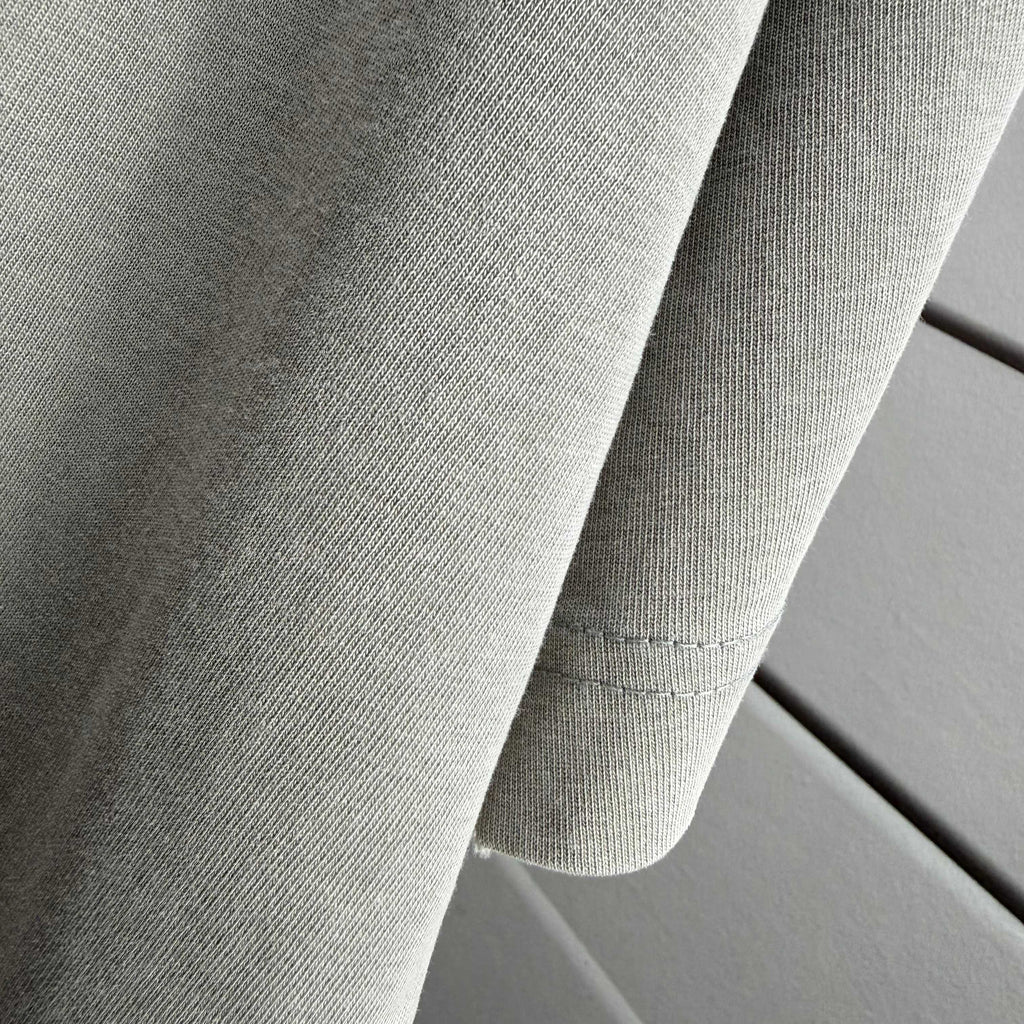 Gray T-shirt fabric with sleeve seam detail and stitched hem