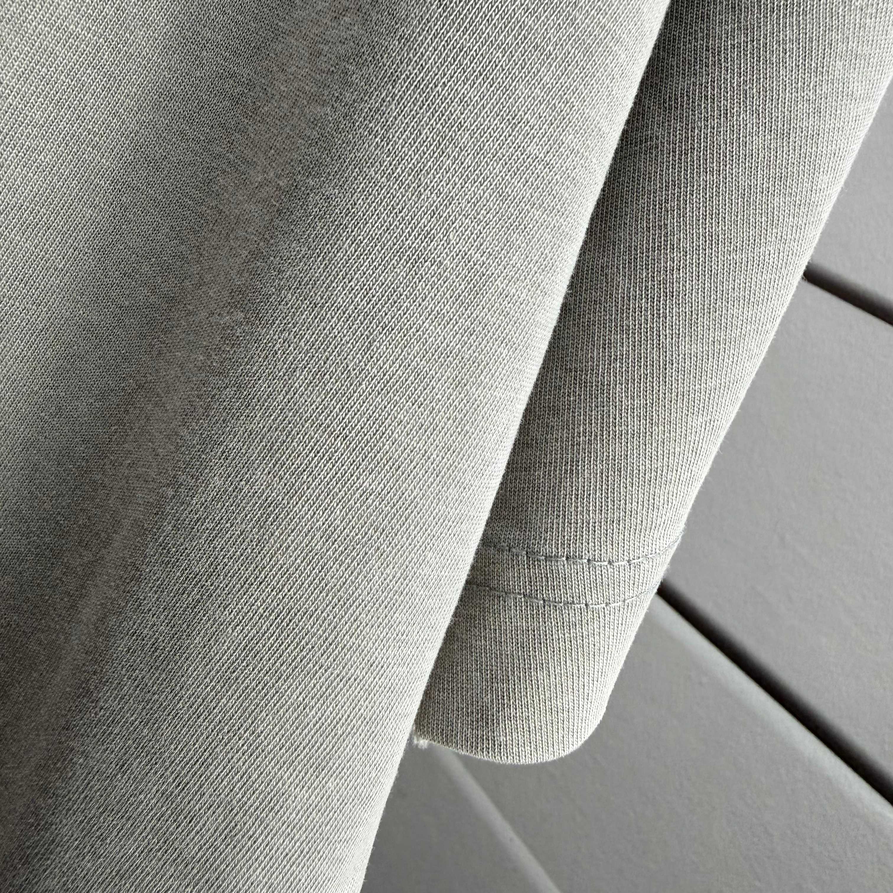 Gray T-shirt fabric with sleeve seam detail and stitched hem