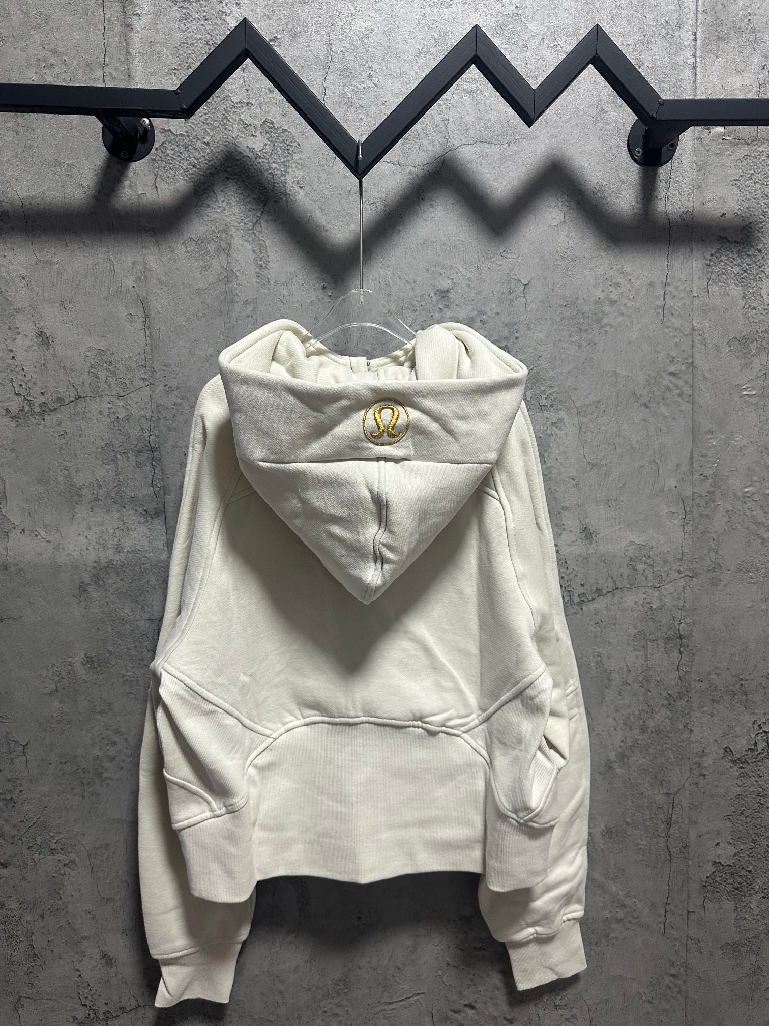 Off-white pullover hoodie with hood and kangaroo pocket, gold logo at chest