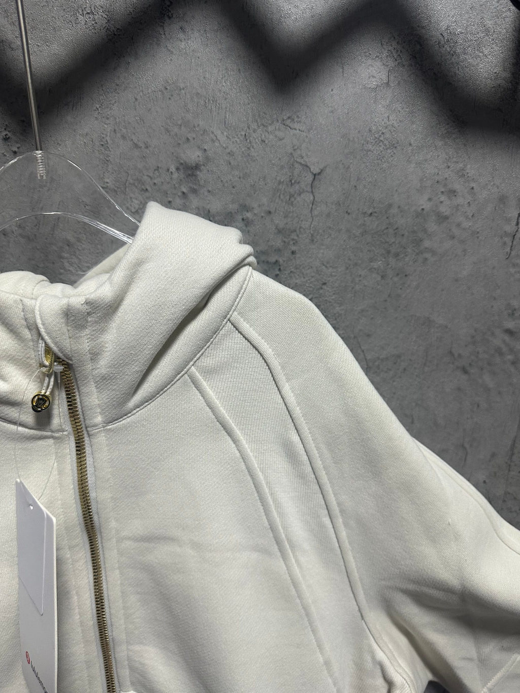 Off-white zip-up hoodie shoulder and hood detail with metal zipper