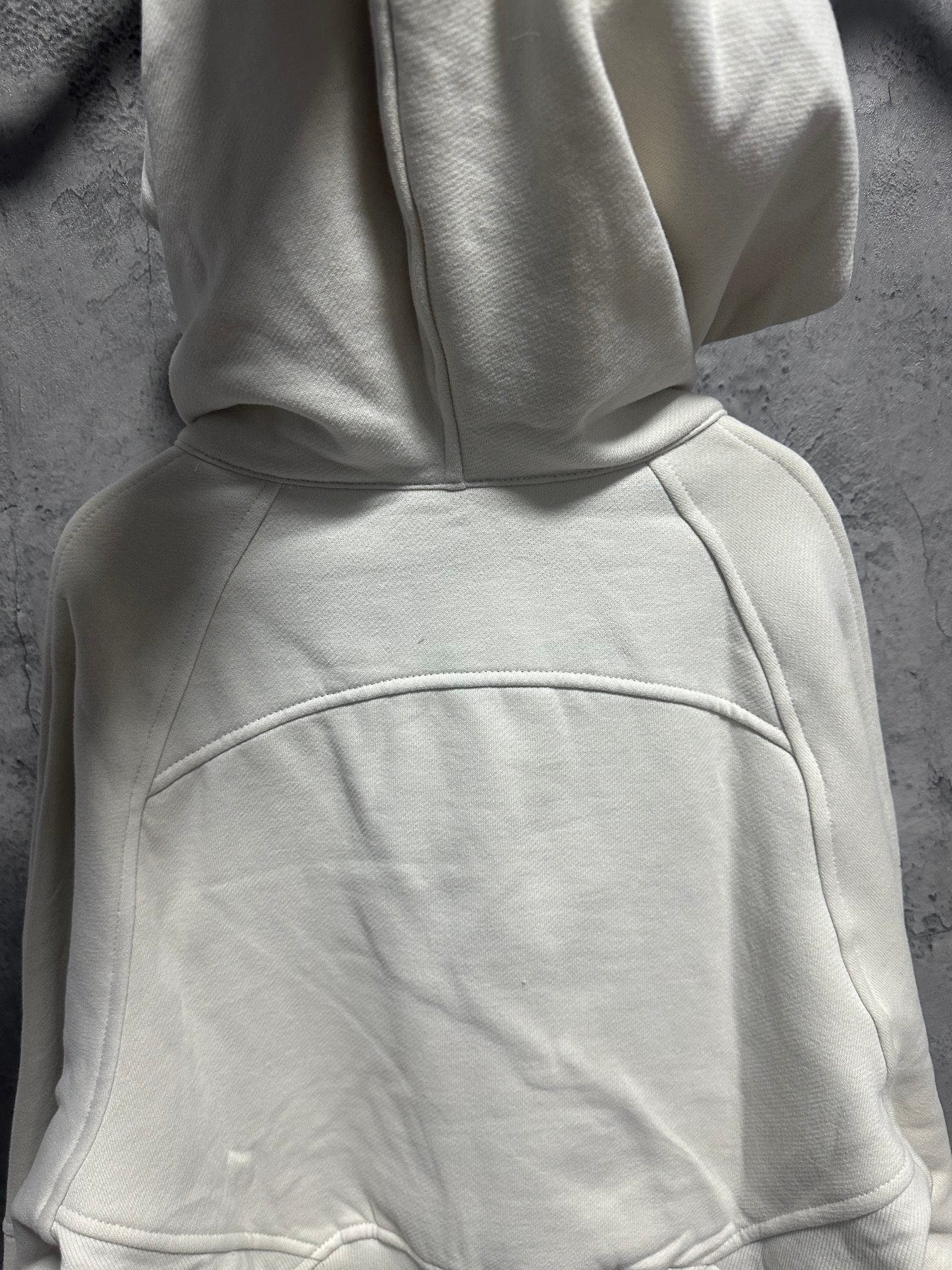 Cream hoodie with kangaroo pocket and stitched panel seams on body