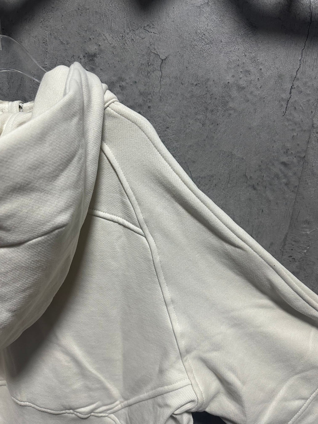 Cream hoodie sleeve and side seam with drawstring channel detail