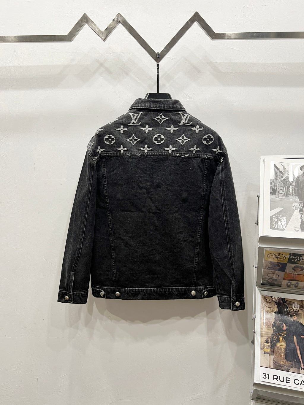 Black denim jacket with LV-style monogram print, back view, buttoned front and metal snaps