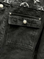 Black denim jacket chest flap pocket with gold-tone button and stitched panel detail