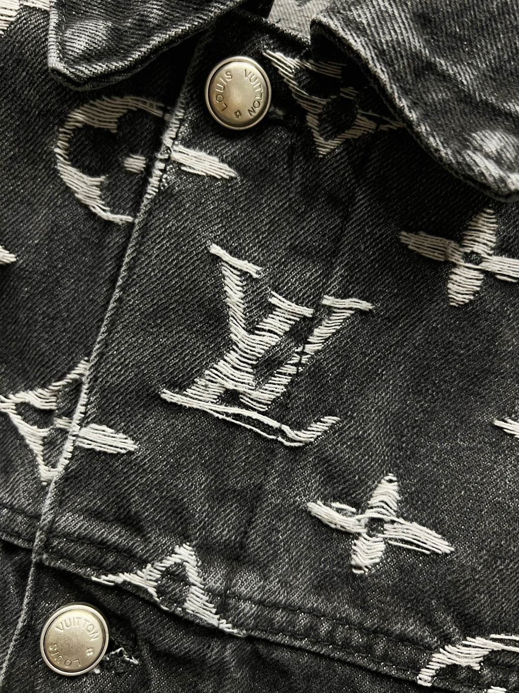 Black denim jacket fabric with LV-style monogram embroidery and gold-tone metal buttons