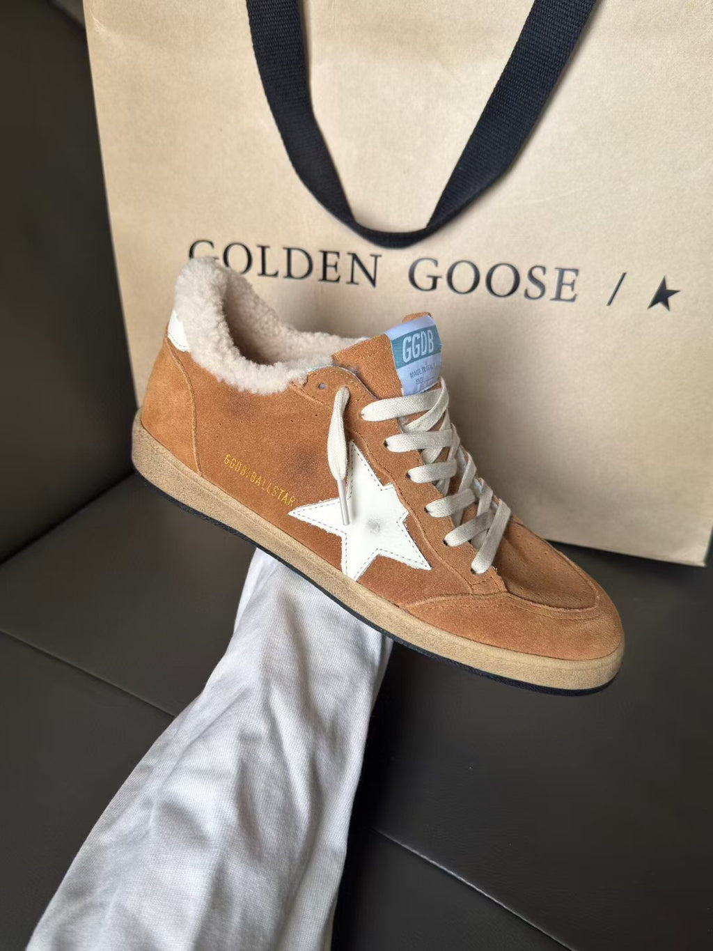 Tan suede high-top sneaker with white star patch, white laces, and fuzzy shearling collar