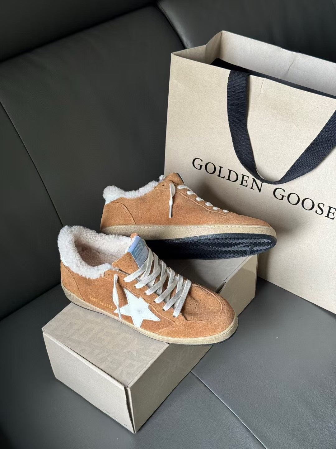 Tan suede lace-up high-top sneakers with white star and fluffy shearling trim, side view
