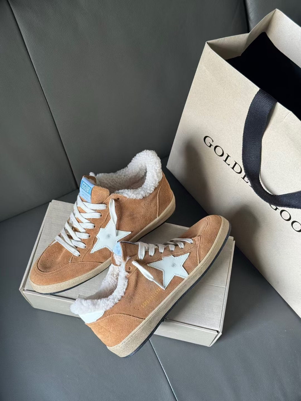 Tan suede sneakers with white star and thick white sherpa lining, front quarter view