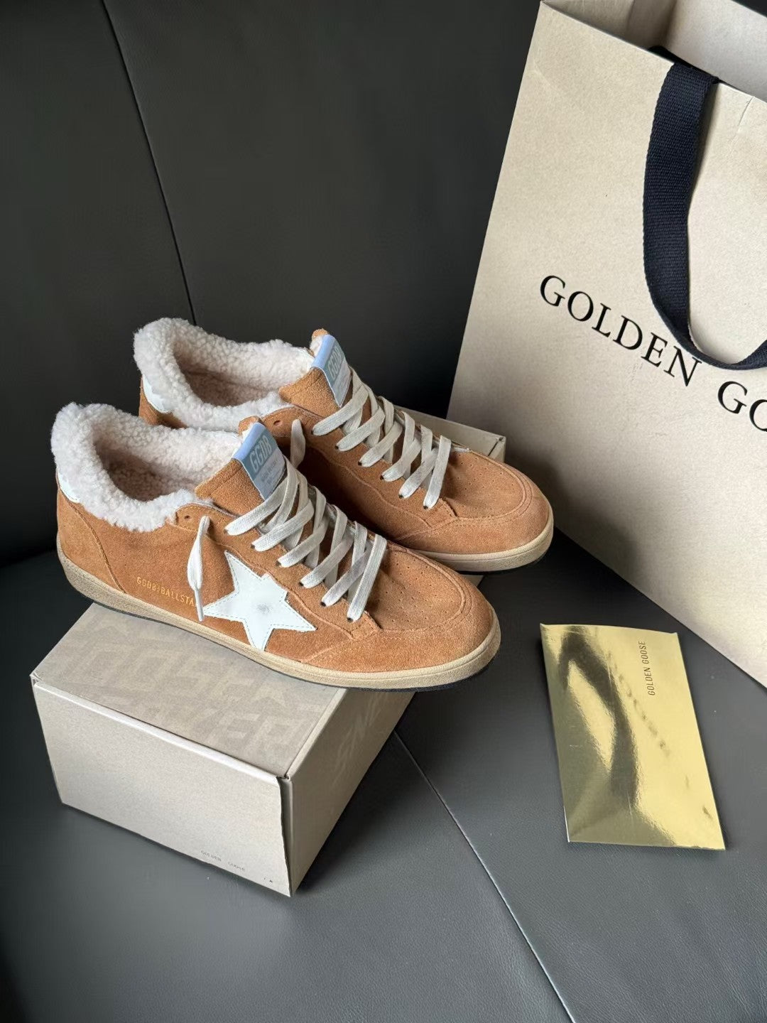 Pair of tan suede lace-up high-top sneakers with white star details and sherpa lining