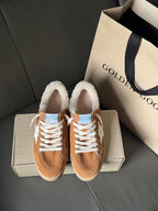 Tan suede lace-up high-top sneakers with white star, sherpa collar, on light gray box