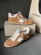 Tan suede sneakers with white star, white laces, and sherpa lining, on gray box