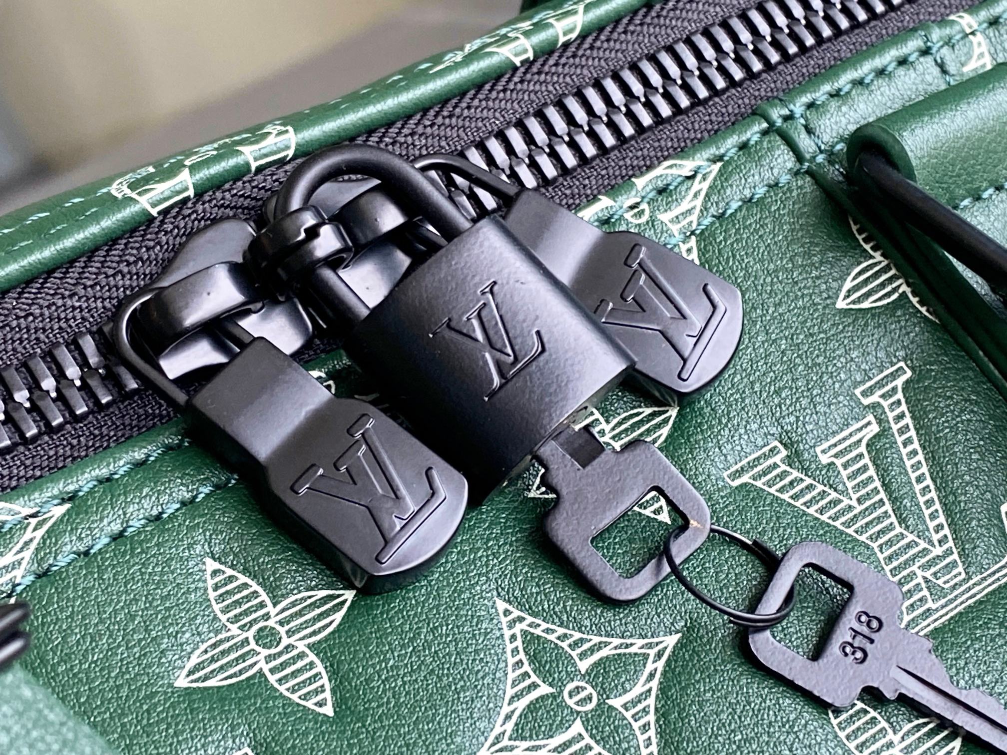 Men’s Louis Vuitton green monogram duffel bag close-up of zipper pulls and hardware