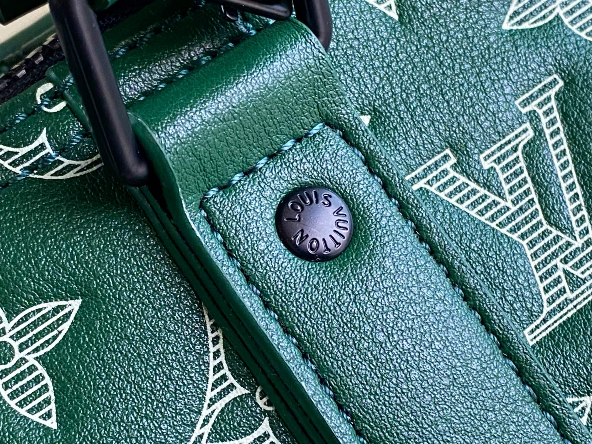 Men’s Louis Vuitton green monogram duffel bag close-up of logo rivet on strap