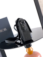Dior leather crossbody bag with shoulder strap and front flap closure, dark finish
