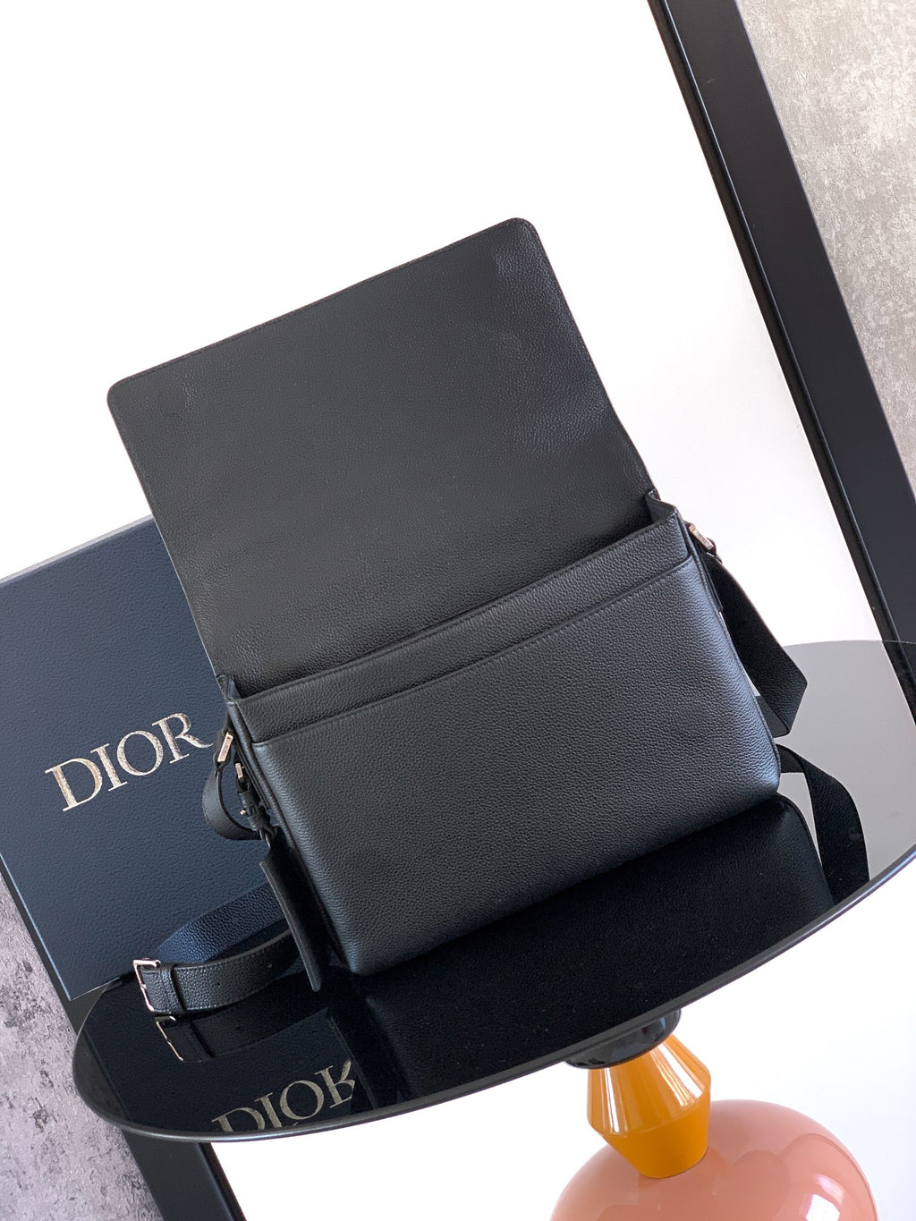 Dior leather crossbody bag with front flap and side strap tabs, dark finish