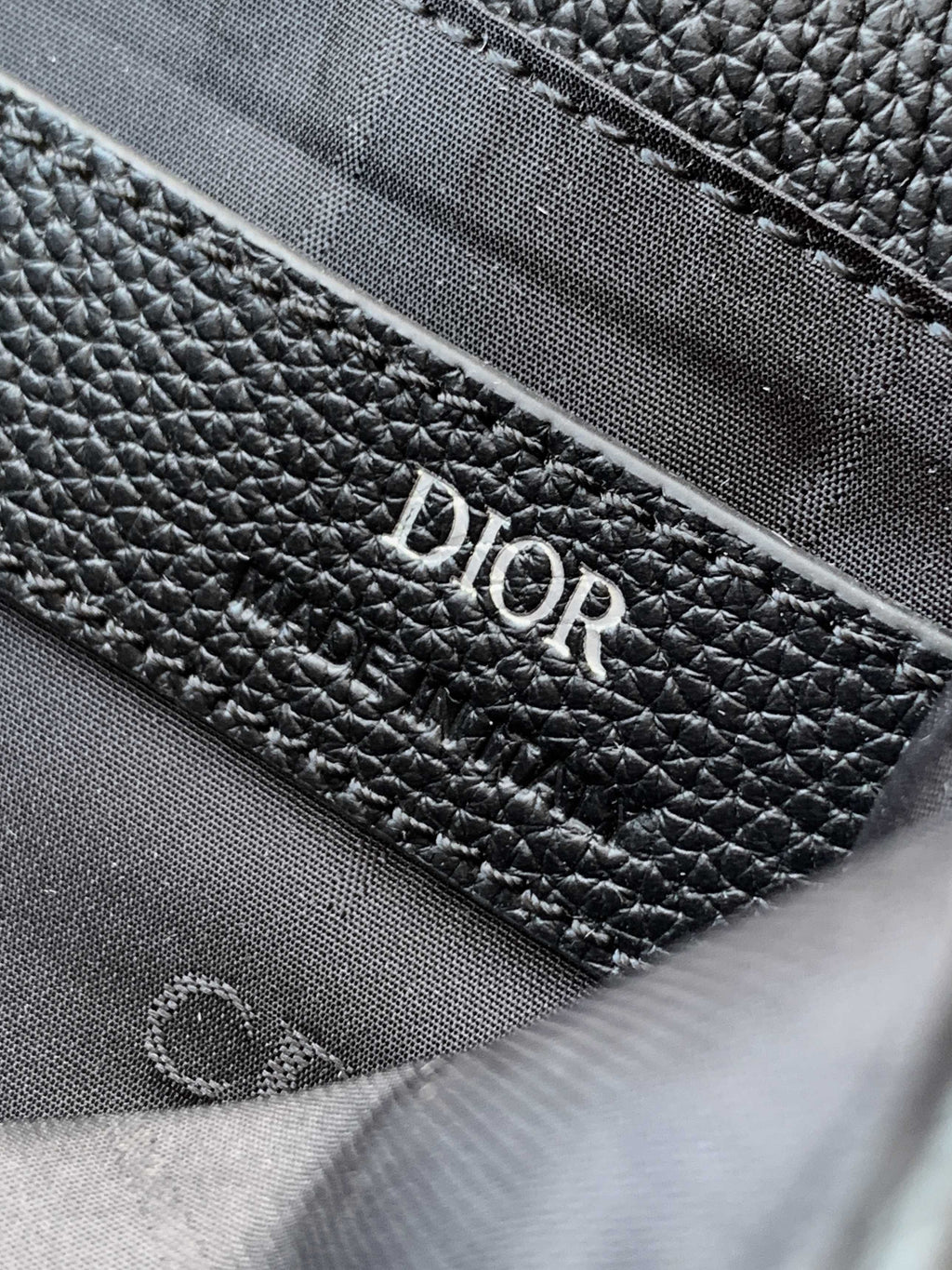 Dior leather bag interior close-up with textured lining and Dior branding