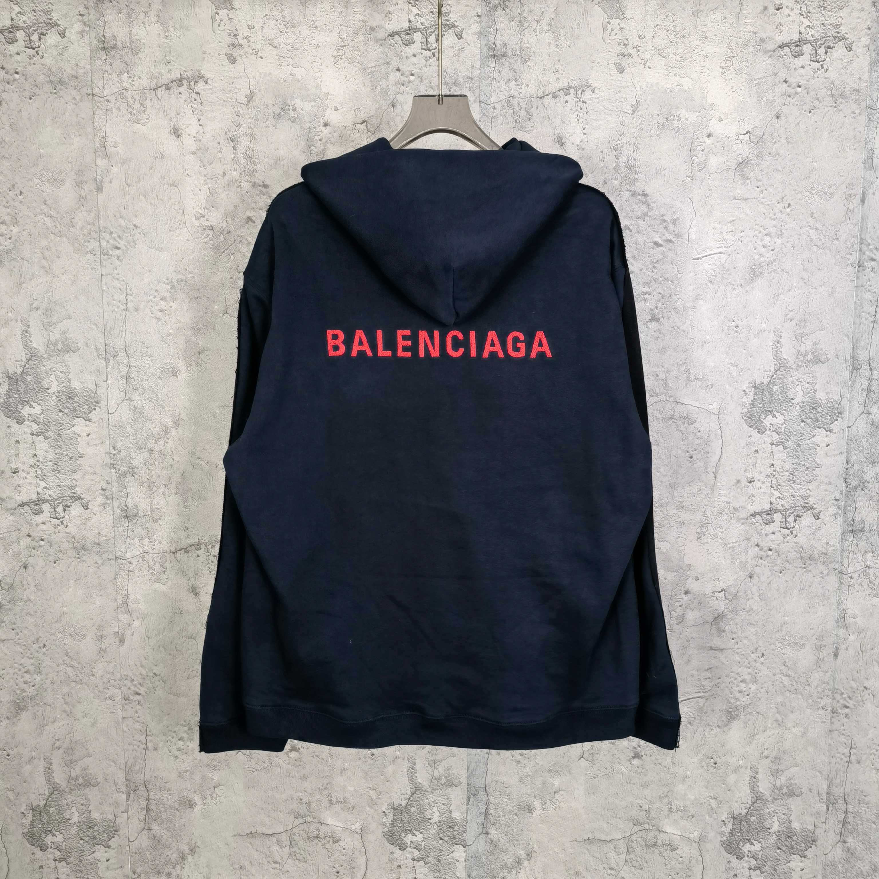 Navy hooded jacket with red BALENCIAGA logo on the back and snap front.