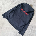 Navy hooded jacket with red BALENCIAGA logo on the back, laid flat.