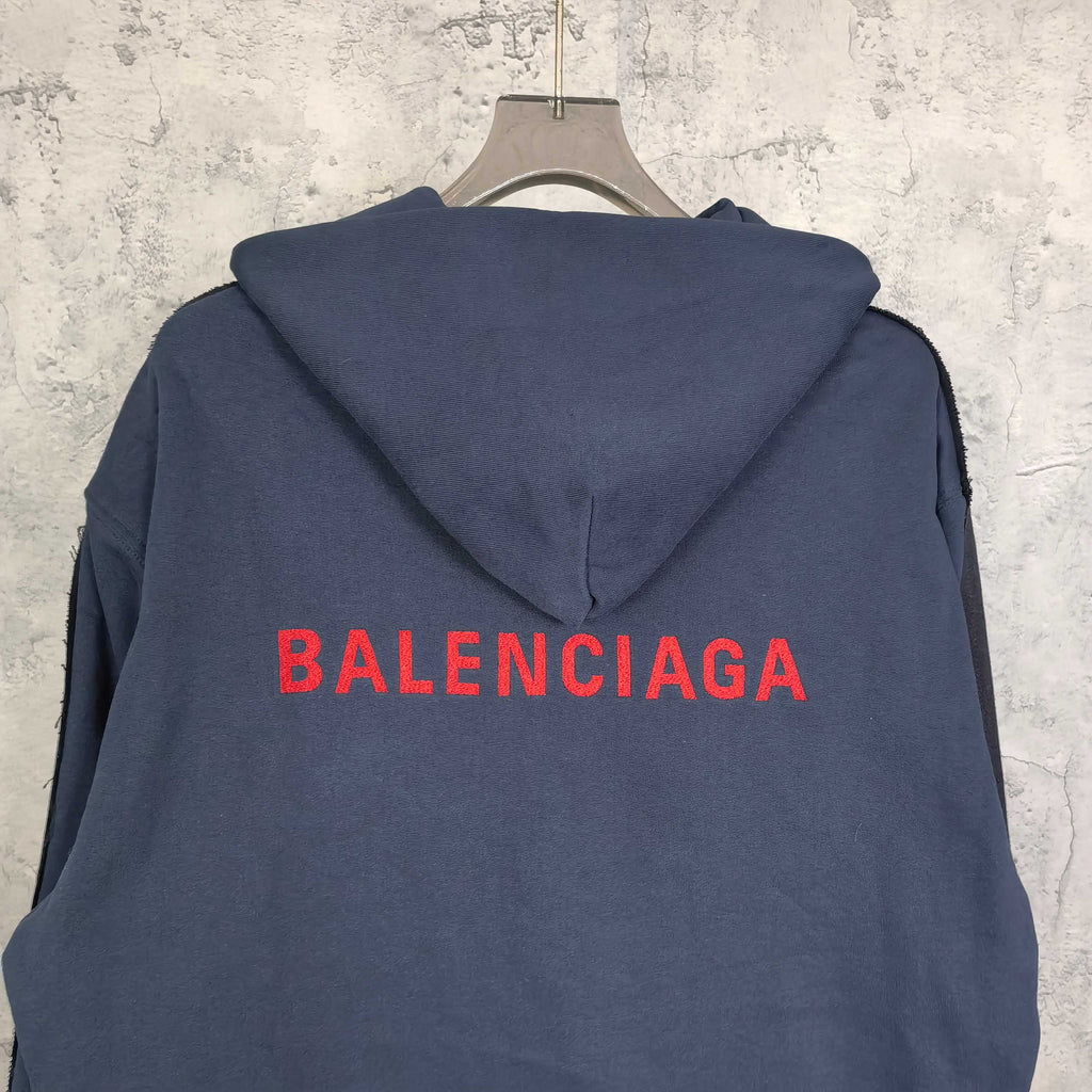 Navy hooded jacket with red BALENCIAGA logo across the back and snap front.