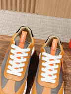 Hermes sneakers pair, orange leather and gray panels with white laces and logo tags