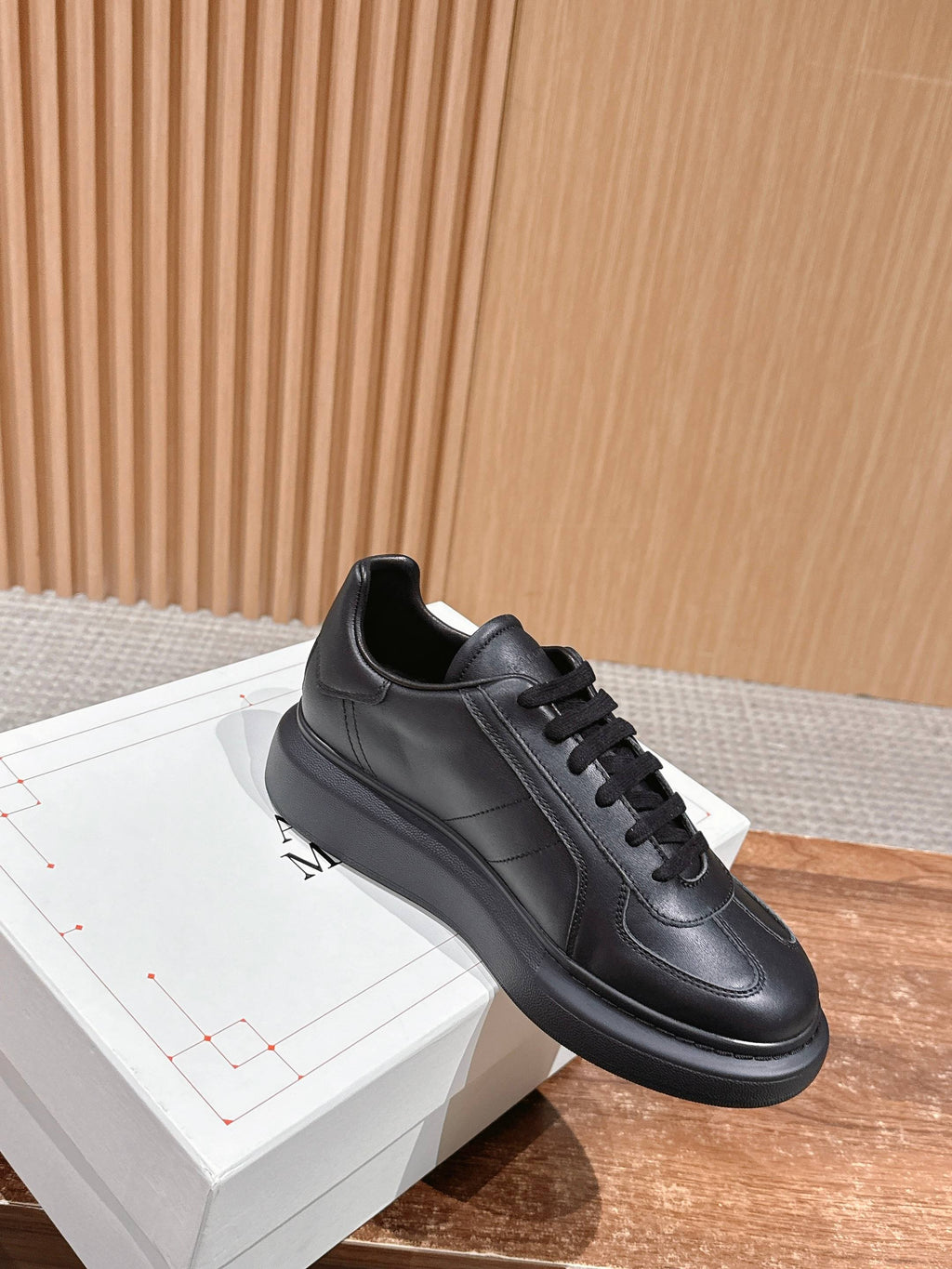 Black leather lace-up sneaker with low profile sole and stitched side panels