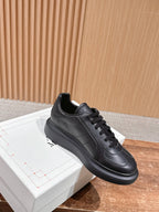 Black leather lace-up sneaker with low profile sole and stitched side panels