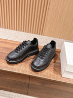 Black leather lace-up sneakers shown side by side on a display platform