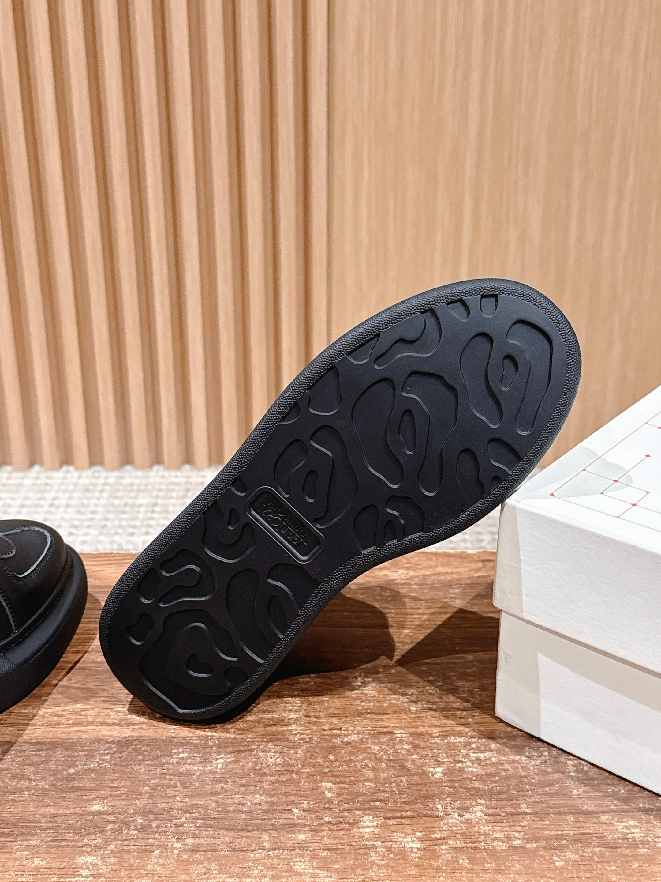 Black rubber outsole with raised tread pattern for a leather lace-up sneaker