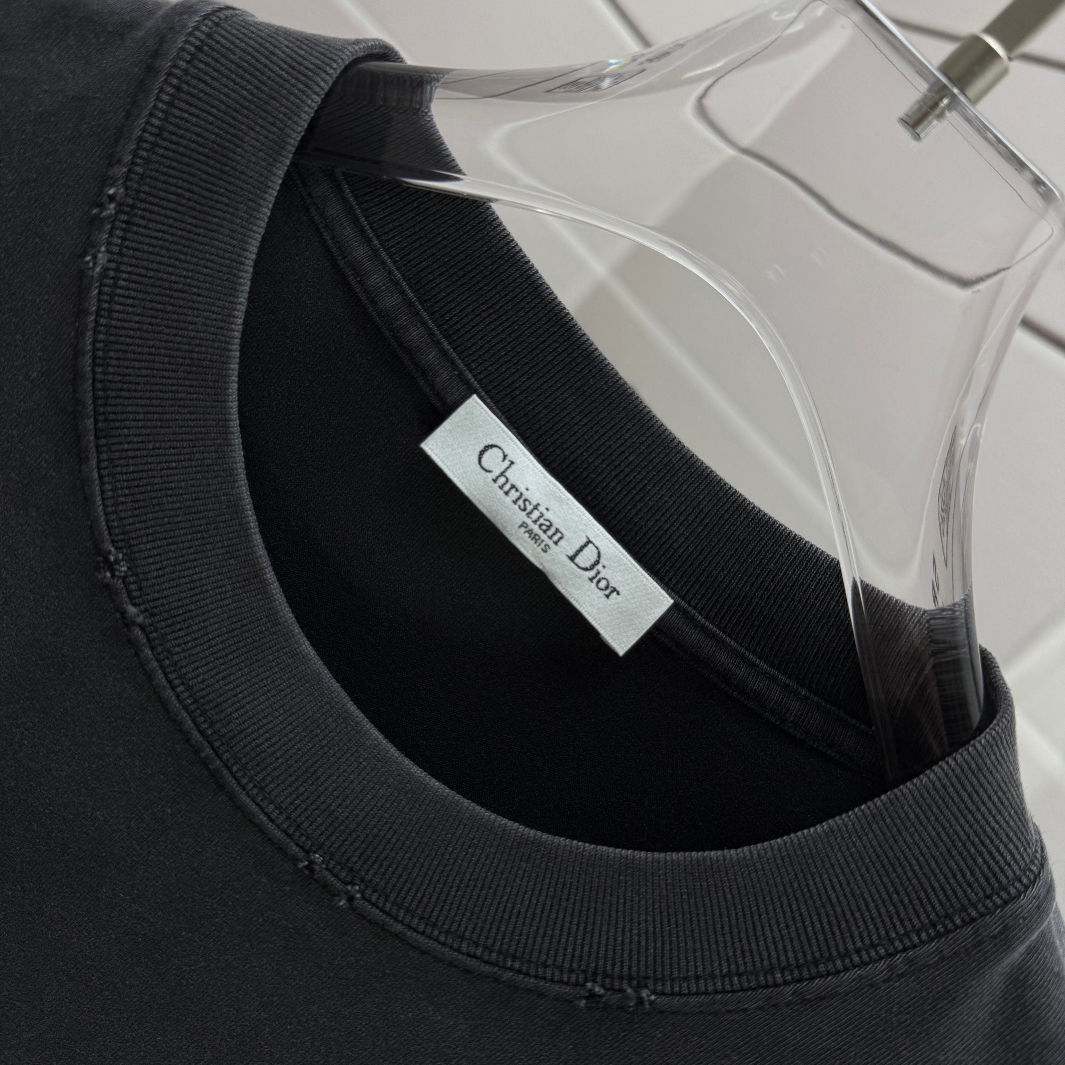 Black crewneck T-shirt neckline with embroidered brand tag