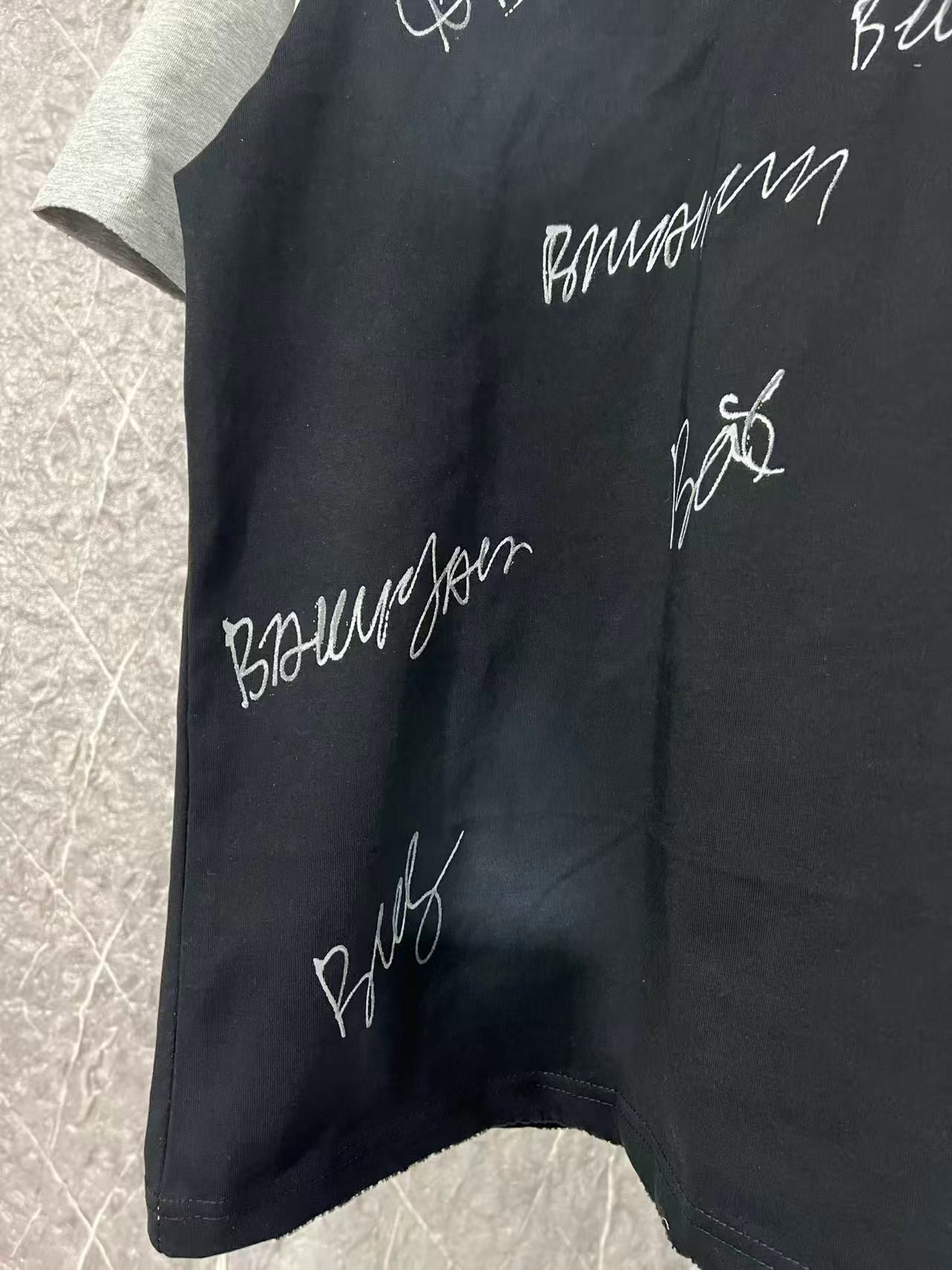 Black raglan T-shirt with side cursive print and stitched hem