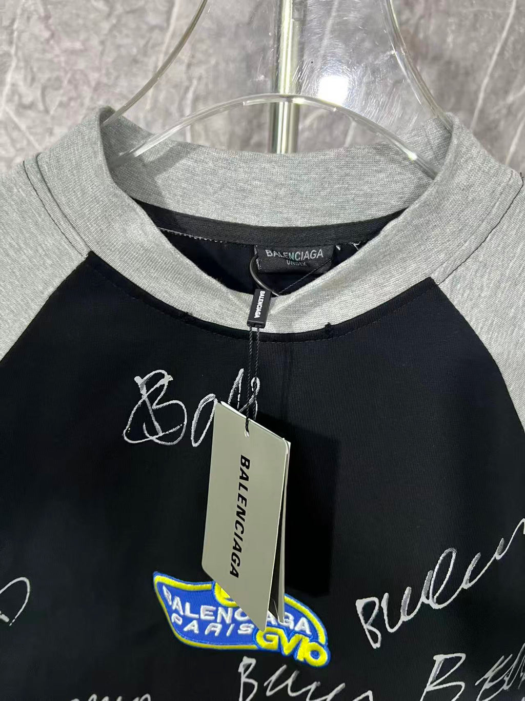 Black raglan T-shirt with heather gray crew neck and hanging tag