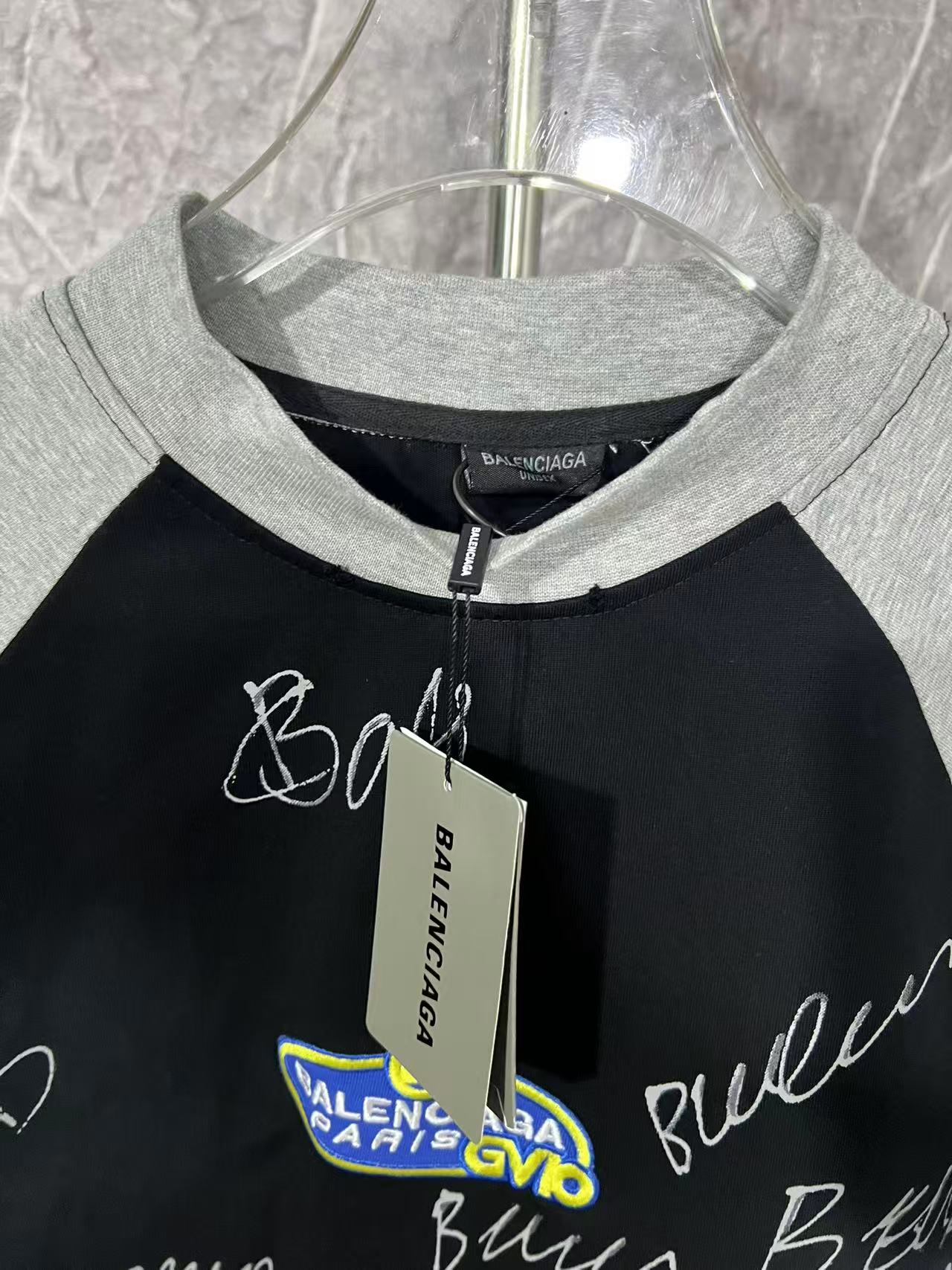 Black raglan T-shirt with heather gray crew neck and hanging tag