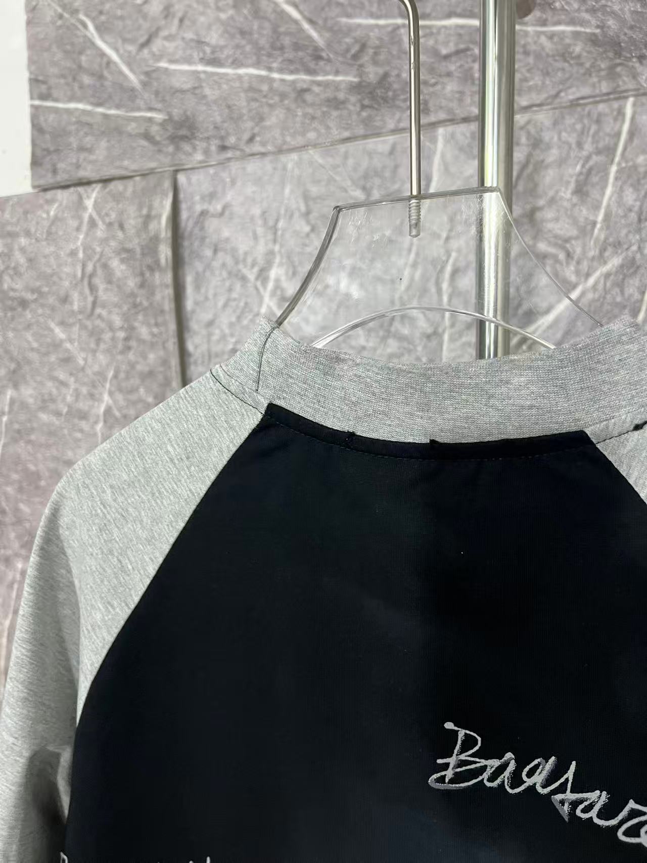 Black raglan T-shirt with heather gray neckline and partial right-side print