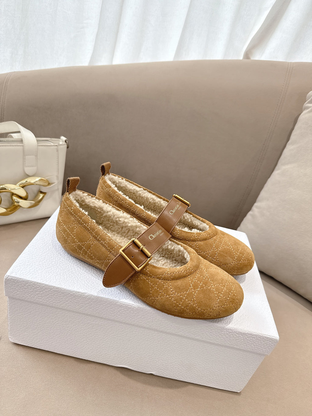 Tan suede flats with gold buckles and cream lining, side view