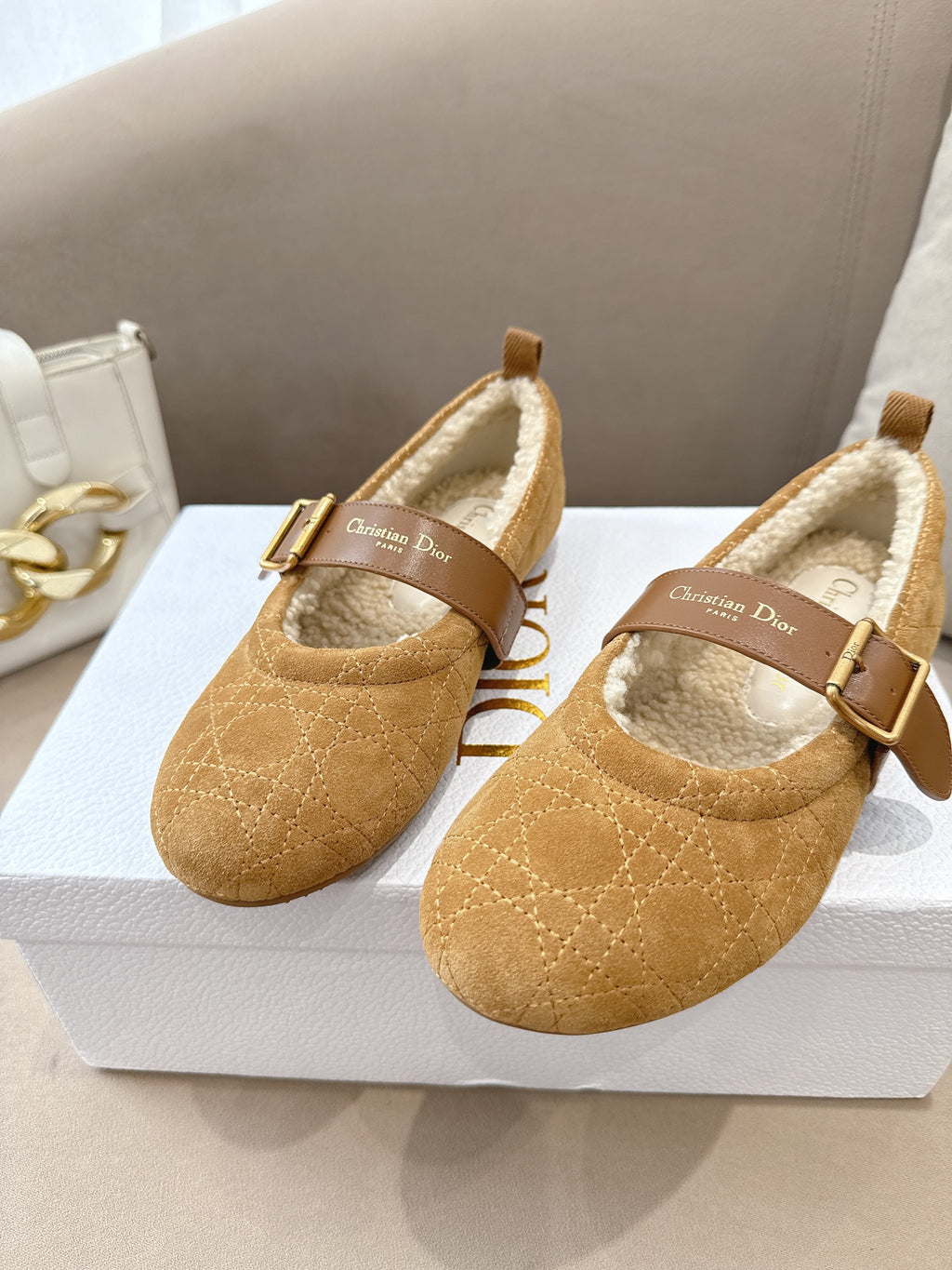 Tan suede flats with buckled strap and cream shearling interior, front view