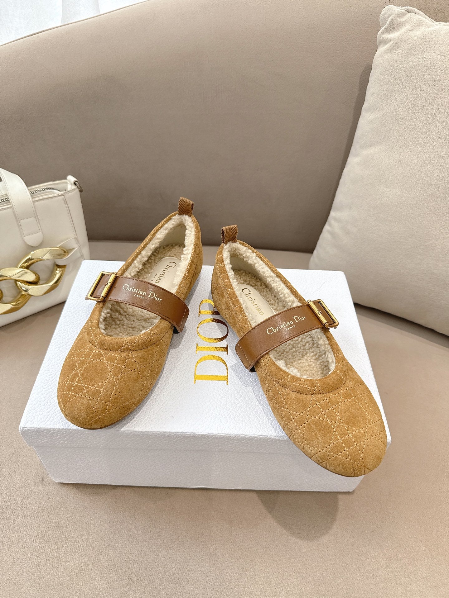 Tan suede flats with buckled strap and cream shearling lining, angled side view