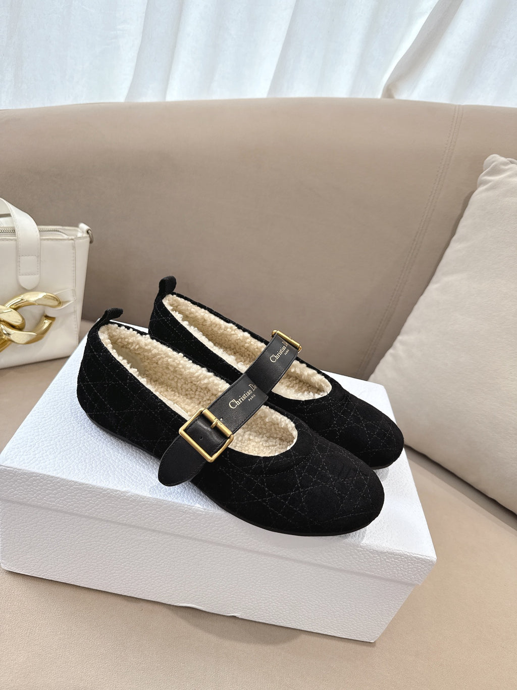 Women's black Dior loafers with gold buckle and shearling lining, angled view