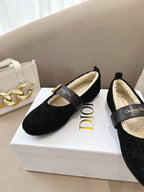 Women's black Dior loafers with gold buckle and cream shearling lining, front view