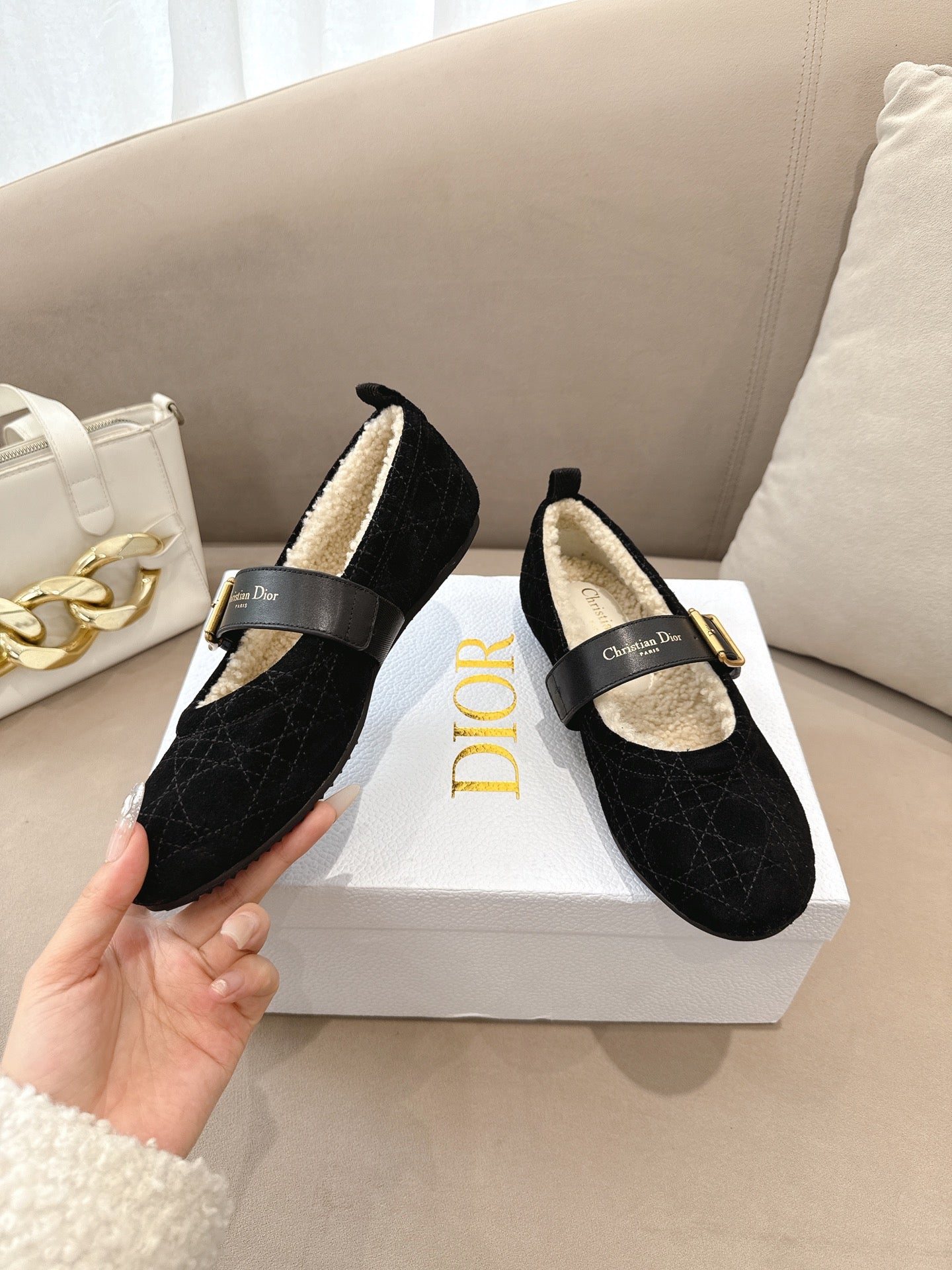 Women's black Dior loafers with gold buckle and shearling-lined insole, worn-in hand