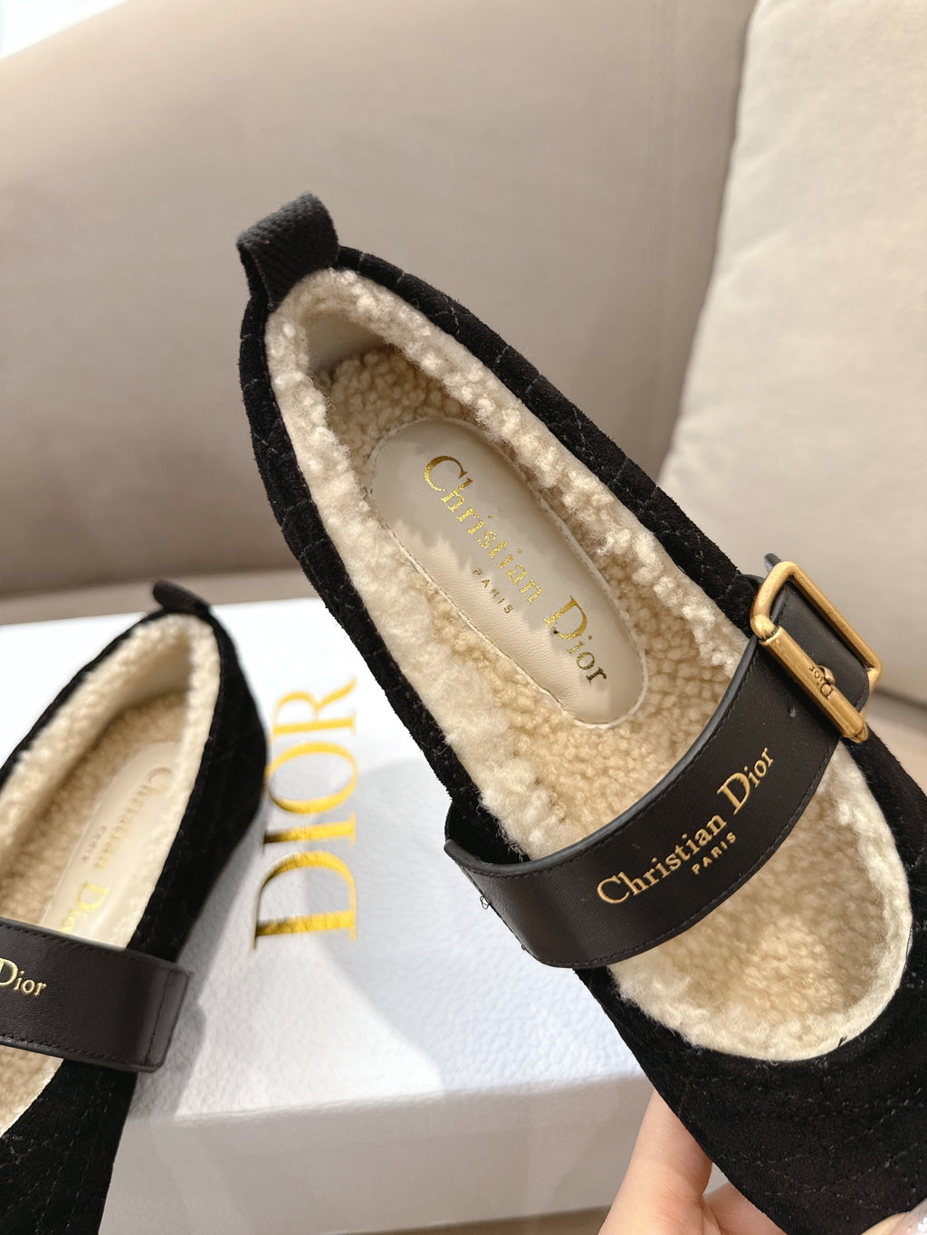 Women's black Dior loafer close-up showing shearling-lined interior and brand label