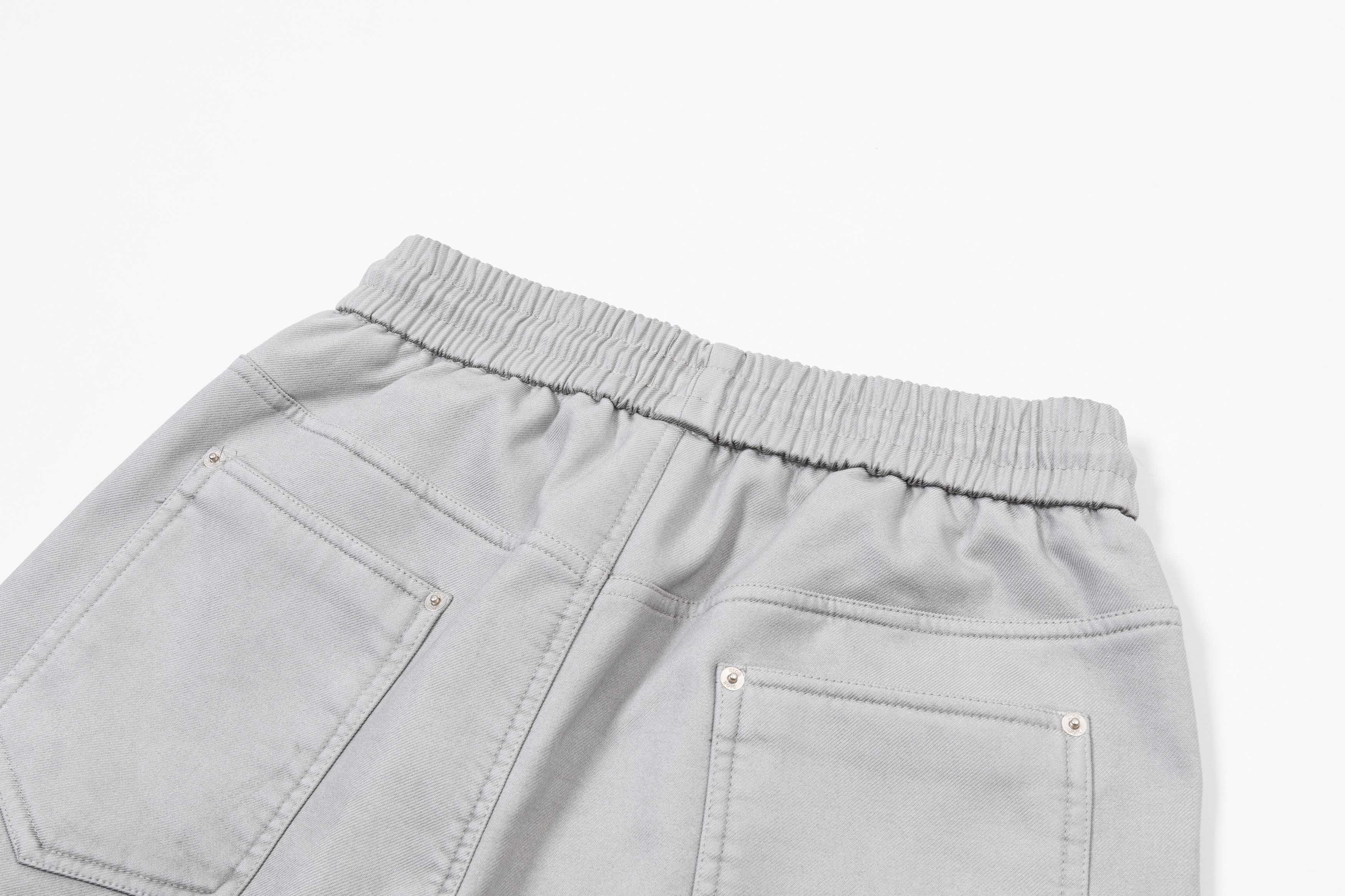 Light gray denim-style pants with elastic waist and stitched pockets
