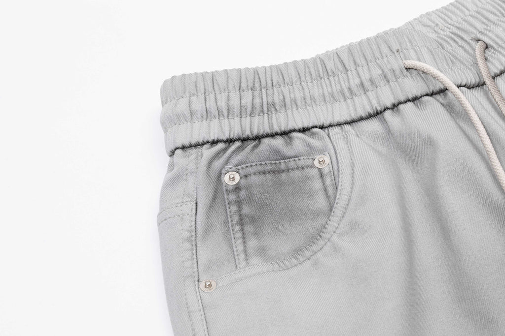 Light gray patch pocket pants with metal snaps and elastic waistband