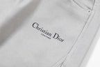 Light gray pants leg with embroidered Christian Dior logo