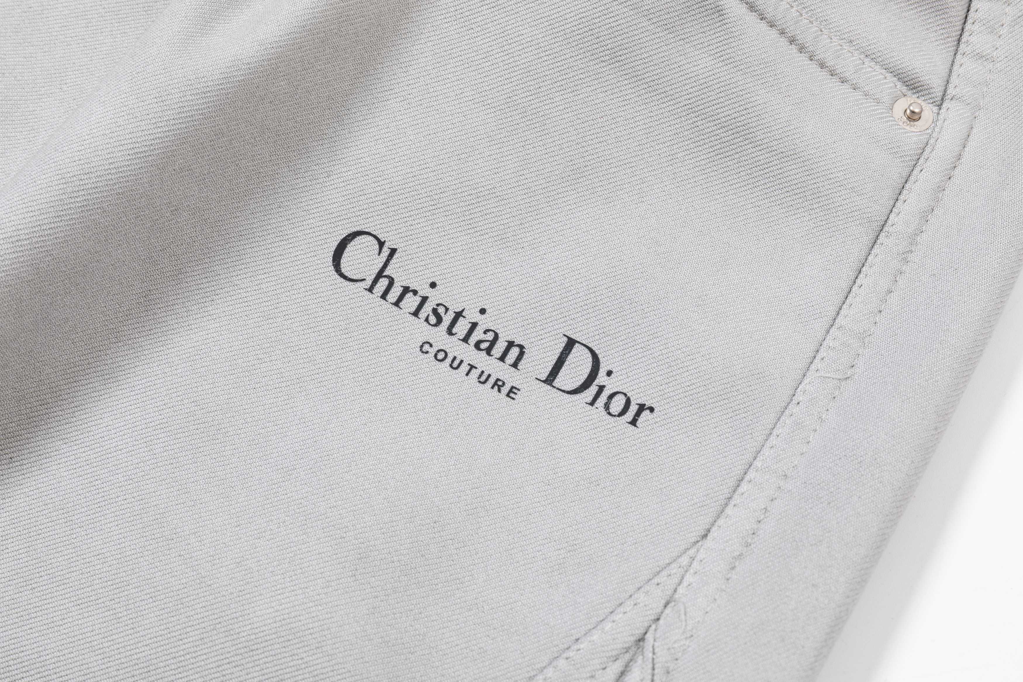 Light gray pants leg with embroidered Christian Dior logo