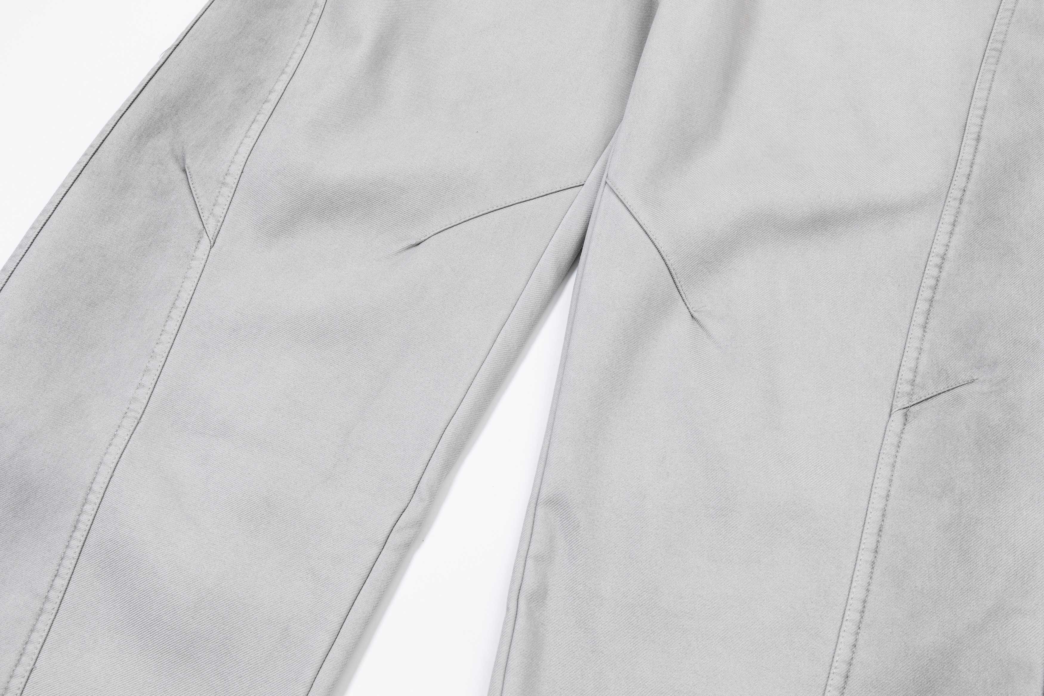 Light gray pants close-up of stitched seams and leg panels
