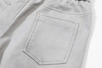 Light gray pants with front patch pocket and visible topstitching