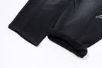 Black pants hem with cuffed cuff detail and draped drawstring