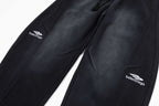 Black pants close-up showing front seams, pockets, and Balenciaga logos
