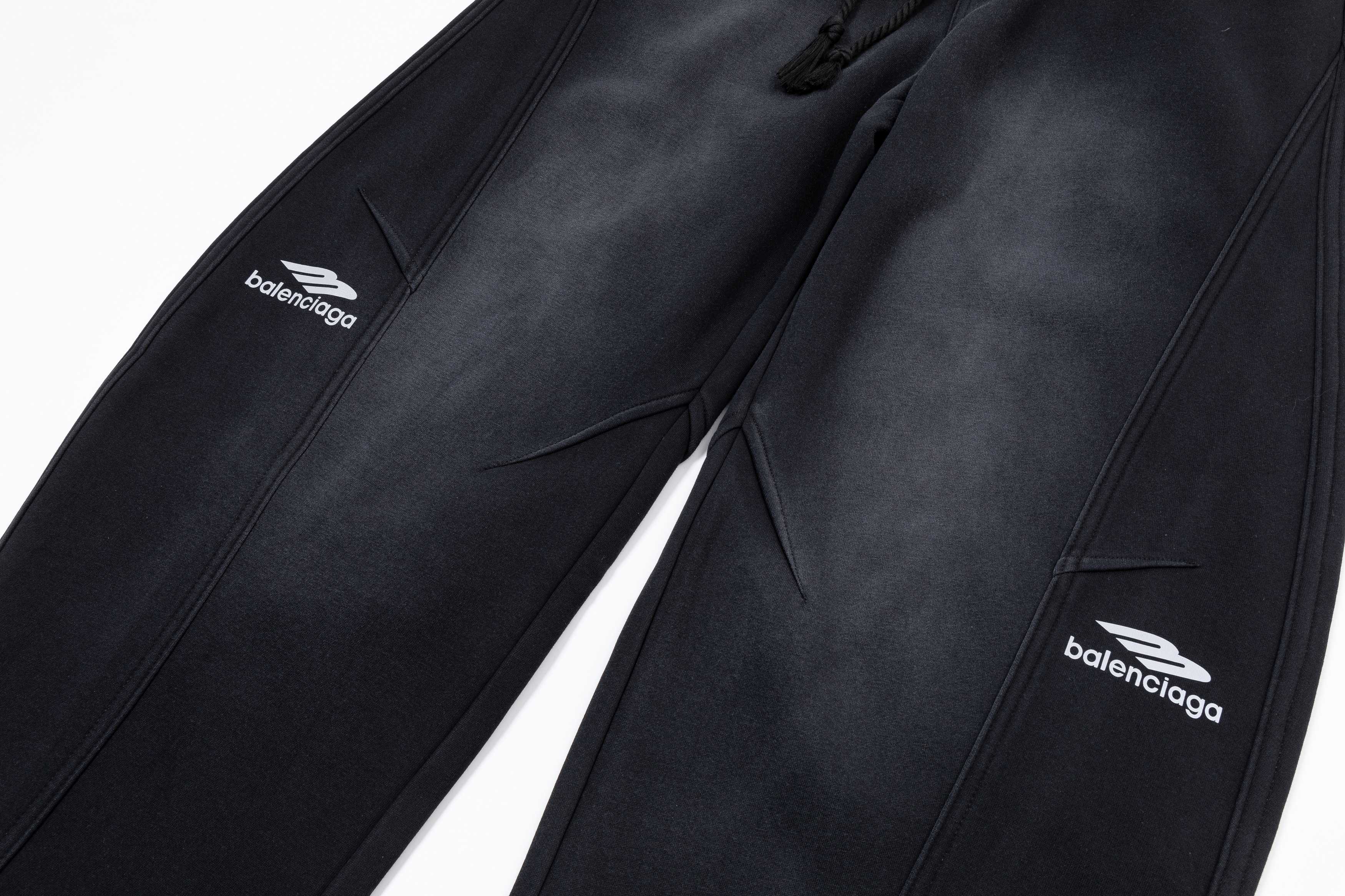Black pants close-up showing front seams, pockets, and Balenciaga logos