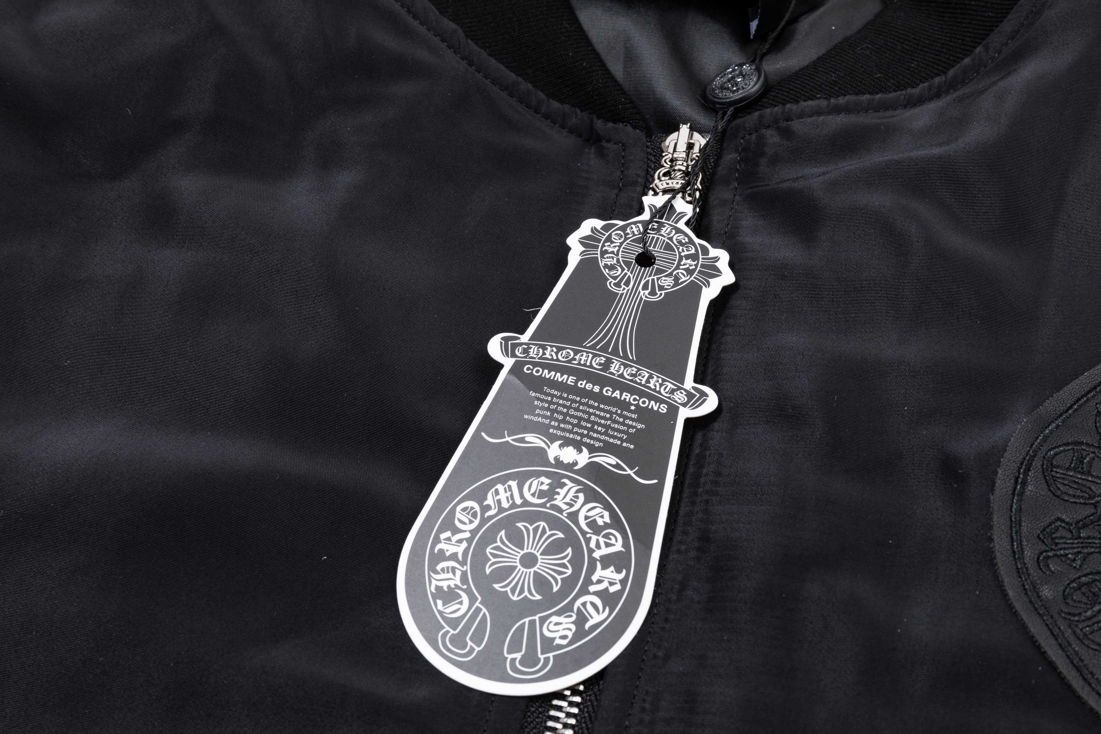 Black bomber jacket neck tag with zipper pull and metal hardware